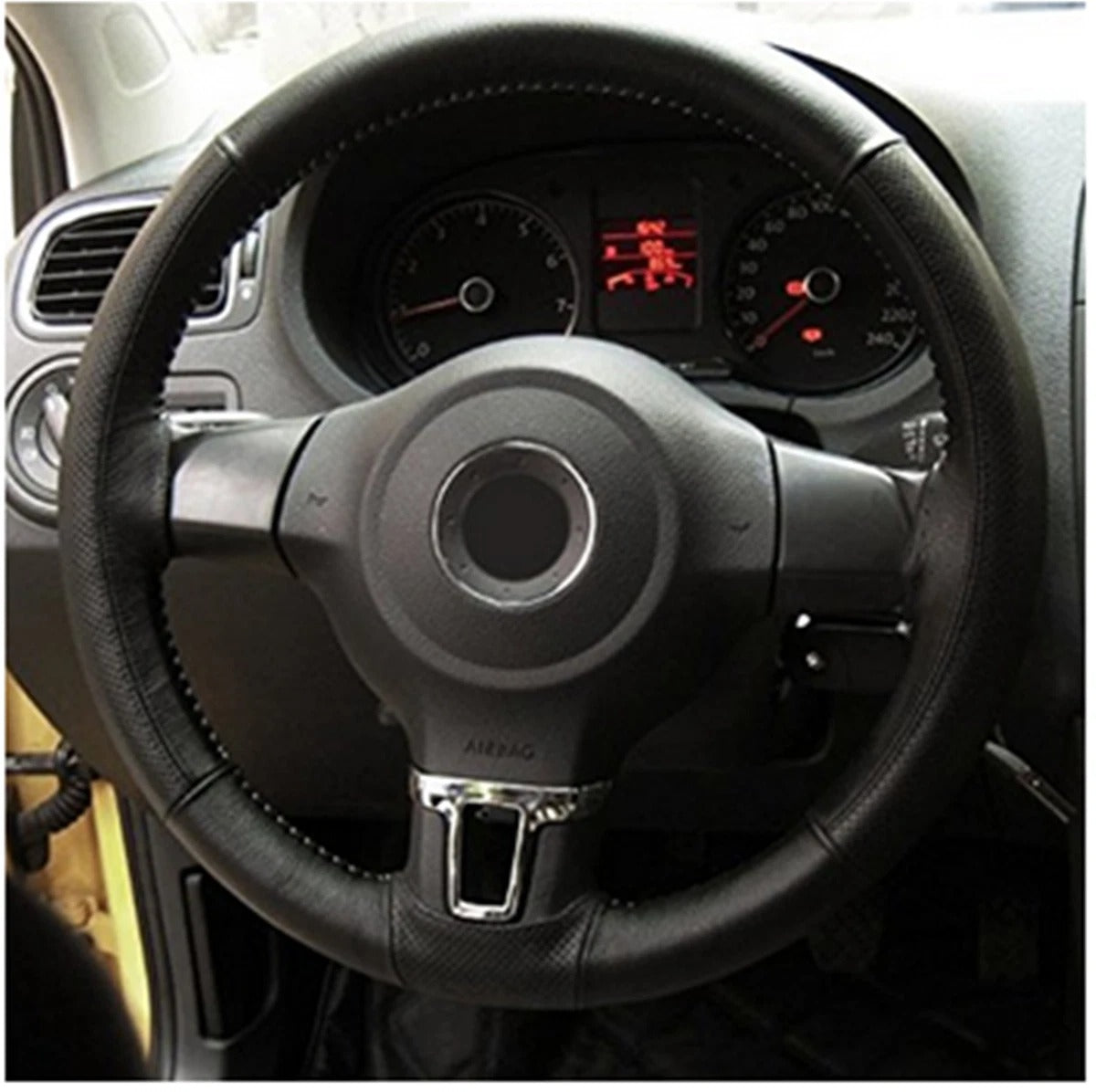 Steering wheel and dashboard of a car with visible gauges.