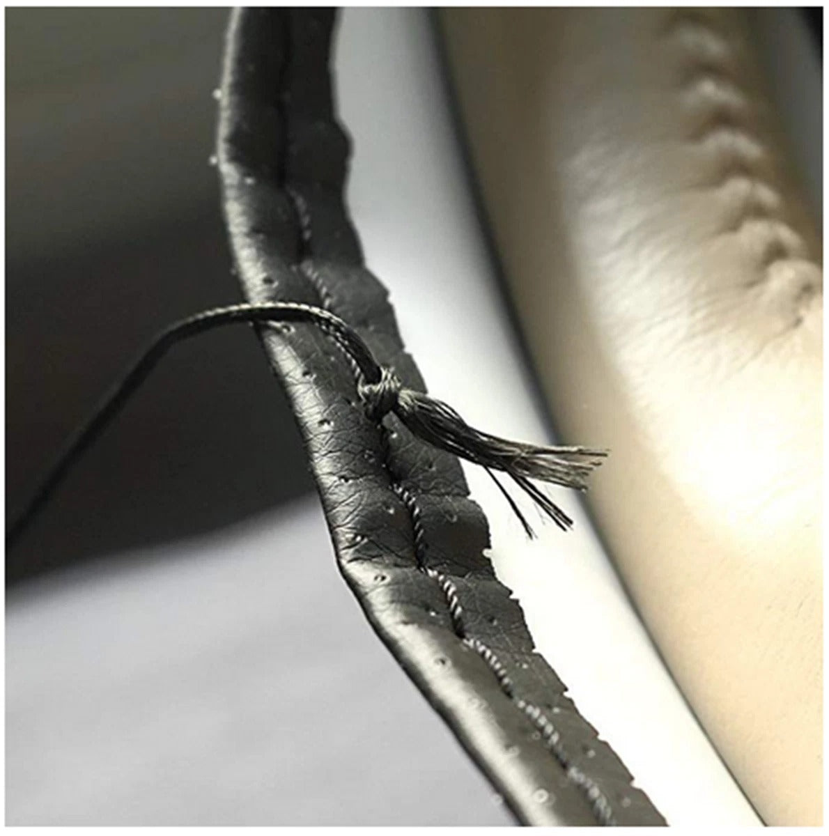 Close-up of a leather strap with stitching on a white background